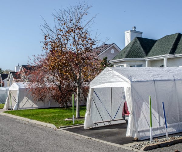 Residential street with winter car shelters during day of autumn